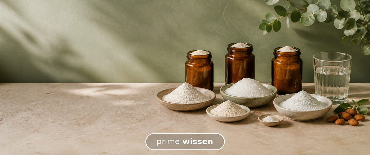 Verschiedene helle Mineralpulver in Schalen neben Wasser und grünen Blättern